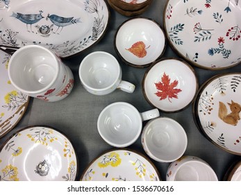 Ceramic tableware top view on wood background. Antique vintage multicolored empty plate on old wooden table. Hand-painted plate. Flower drawing on ceramics
