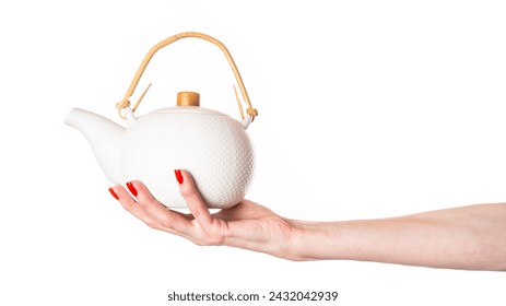 Ceramic teapot in female hand isolated on white background. White teapot. High quality photo