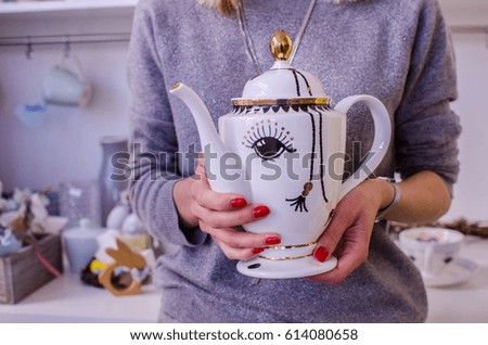 
Ceramic teapot in hands