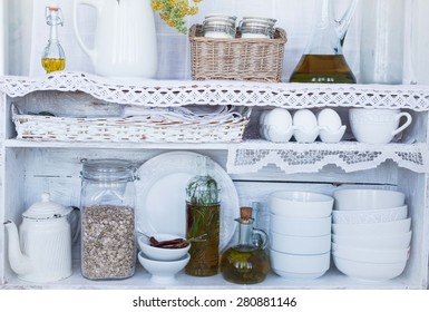 Ceramics and kitchen equipment and food products on rustic and country style wooden shelves