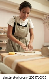 Ceramist Kneading Clay In Studio