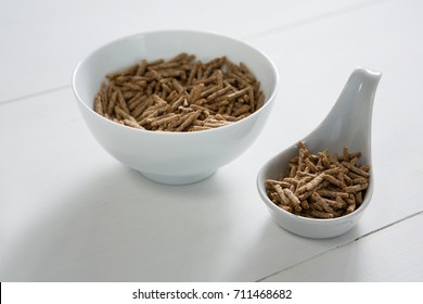 Cereal bran sticks in bowl and spoon on white background - Powered by Shutterstock