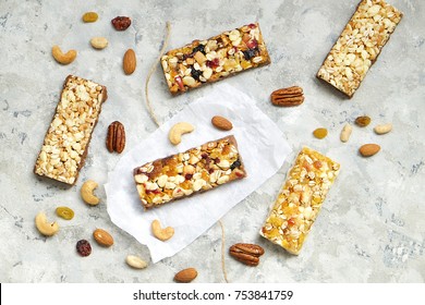 Cereal granola bars with nuts and fruit berries, with ingredients on a stone table. Top view healthy snack.  - Powered by Shutterstock