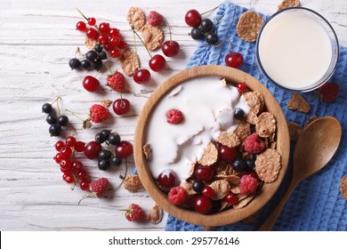 cereal with milk and fresh berries in a wooden bowl. horizontal view from above 