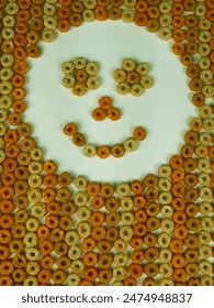 Cereal, Multigrain hoops, background texture. Brown colours behind a white background. 'happy hoops' smiley face. Colorful cereal pattern with space for text. High-key lighting. 