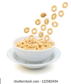  cereal rings falling on a bowl on a white background
