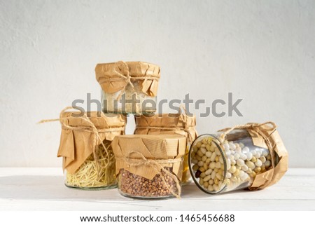 Cereals in glass jars on a light background with a shadow. Eco storage, zero waste