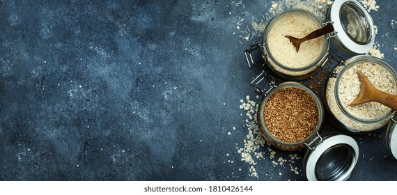 Cereals (oatmeal, Buckwheat, Rice) In Glass Jars In The Kitchen Banner Background. Gluten Free Concept. Varieties Of Cereals For Making Healthy Homemade Food And Meals.