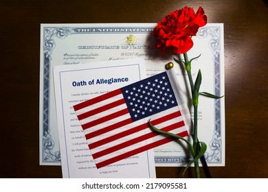 Certificate Of Naturalization, Oath Of Allegiance, American Flag And Red Carnation Flower Given To A New US Citizen After Naturalization Ceremony