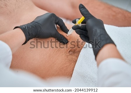 Certified aesthetic doctor carrying out a mesolipolysis procedure