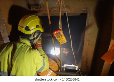 Certified Site Safety Officer Inspector Conducting Inspection Safety Check On Worker When Gas Testing Atmosphere Detector Starting Warning Sound Alert, While Friend Is Working Inside Confined Space 