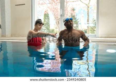 Certified swim instructor instructing beginner swimmer in water