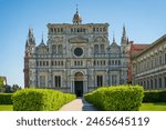 Certosa di Pavia monastery, historical monumental complex that includes a monastery and a sanctuary. green court and a church.The Ducale Palace on the right,Pavia,Italy.