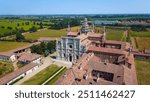 Certosa di Pavia seen from an aerial view, Italian wonders and art, historical monumental complex that includes a monastery and a sanctuary. green court and a church. Pavia, Italy