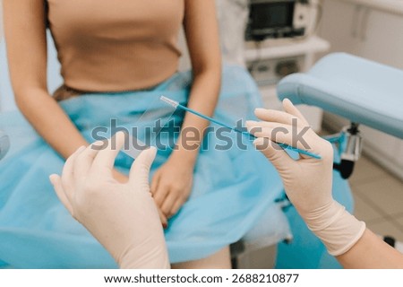 Cervical cells are applied to a microscope slide for examination. A Pap smear sample on a slide for testing. Gynecologist prepares a cytology slide using a sterile brush
