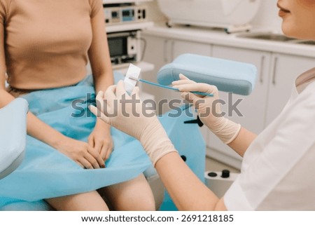 Cervical cells are applied to a microscope slide for examination. A Pap smear sample on a slide for testing. Gynecologist prepares a cytology slide using a sterile brush