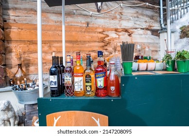 CERVO Hotel, Zermatt, Switzerland. March 15, 2022. Various Liquor Bottles Arranged On Counter. Citrus Fruit Slices In Containers On Table. Food And Drinks At Outdoor Restaurant In Resort.