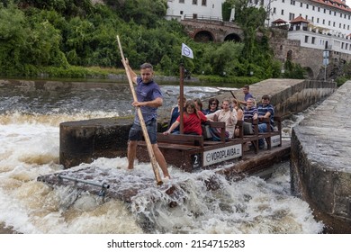 CESKY KRUMLOV, CZECH REPUBLIC - 28. 7. 2021: People on wooden raft (vor) on Vltava river in the historical town of Cesky Krumlov. Water sports (voroplavba) on Vltava river. Laughing, shocked tourists.