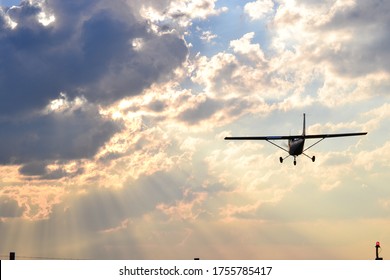 Cessna 150 training aircraft landing at sunset
