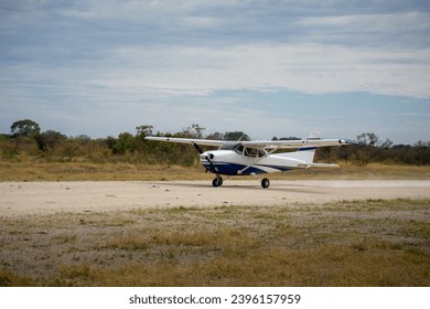 Cessna propeller plane takes off on a gravel runway or airstrip in the Okavango Delta in Botswana, Africa