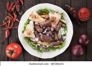 Cevapcici, bosnian minced meat kebab with somun bread, onion and french fries