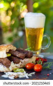 Cevapi, cevapcici, Balkan minced meat kebab served with onion, hot peppers and beer. 