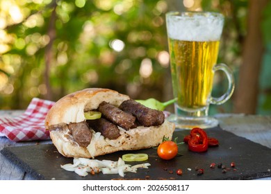 Cevapi, cevapcici, Balkan minced meat kebab served with onion, hot peppers and beer. 