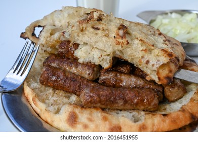 Cevapi or cevapcici. Traditional meat dish in Balkans. Meat prepared on barbecue and served with bread somun and onions. Popular food. 