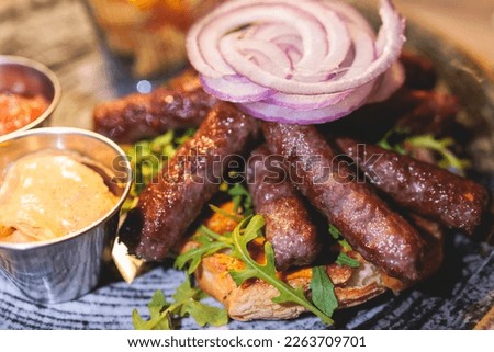 Cevapi on a plate, traditional balkan dish, grilled minced beef meat, Cevapcici, with onion and french fries served in restaraunt in Kotor, Montenegro, balkan cuisine