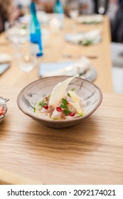 Ceviche Croaker With Grenade Fruit Served On The Plate At Luxurious Dinner At Home. Blurred Group Of Friends Eating. Seafood Plate Ready To Eat. Healthy Lifestyle Concept.