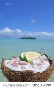 Ceviche Dish Served In A Coconut Shell Against Islet In Muri Lagoon In Rarotonga, Cook Islands. Food Background And Texture. Copy Space