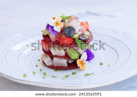Ceviche Layers Dish - appetizer of fresh Tuna fish and Frigate Tuna marinated in citrus with Avocado, Red Onion Strawberries and Blueberries