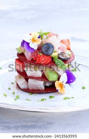 Ceviche Layers Dish - appetizer of fresh Tuna fish and Frigate Tuna marinated in citrus with Avocado, Red Onion Strawberries and Blueberries