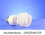 A CFL Compact Fluorescent Lightbulb over a soft blue background.