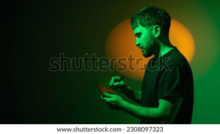 CGI artist draws using a graphics tablet. Digital interactive entertainment industry man working with CGI. Artist creates level design and 3D assets for metaverse. Copy space. Banner.
