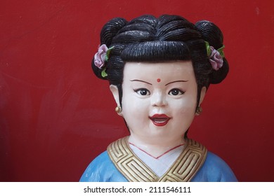 CHACHOENGSAO, THAILAND – JANUARY 23, 2022: A Chinese god statue or Buddhist saint for red wall on the background at Wat Saman Rattanaram temple in Chachoengsao province of Thailand.