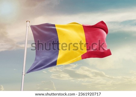 Chad national flag waving in beautiful sky.