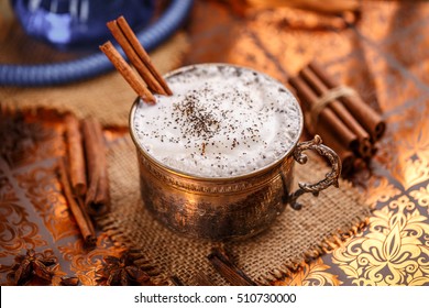 Chai latte spiced black tea beverage in antique mug with cinnamon