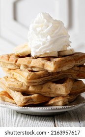 Chai Spiced Waffles Stacked High With Whipped Cream And Sliced Bananas