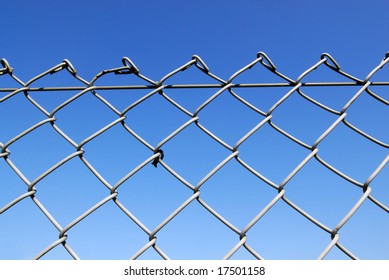 Chain link fence with blue sky background - Powered by Shutterstock