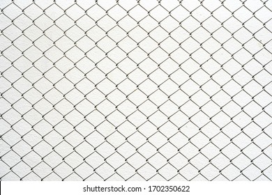 Chain link fence. Steel wire mesh isolated on white wall background.