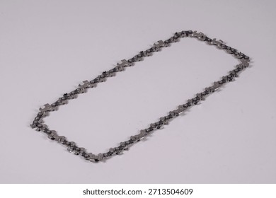 Chain links are arranged in a rectangular shape on a plain surface. The links are metallic and show a pattern that connects each part securely.