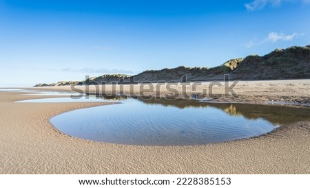 A chain of tidal pools seen on Formby beach reflecting the sand dunes which line most of the Sefton coastline between Liverpool and Southport.