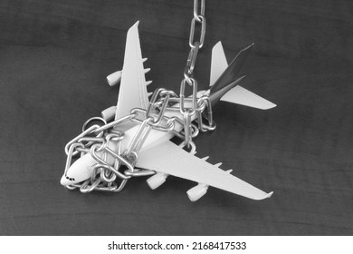 Chained airplane model close-up. Flight cancellation and sanctions concept. 