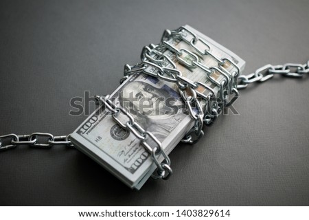 chained money, the concept of frozen assets. dark background, closeup
