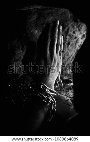 Chained prisoner is praying