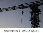 chains, Hook from a tower crane for lifting cargo isolated on blue sky background. mobile construction crane lifts a load with a hook and chains. Close-up of a construction crane hook at work