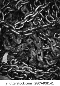 chains in an industrial or construction setting with a close-up perspective, showcasing utilitarian materials and a clean, modern aesthetic. The scene highlights the gray and black metal.