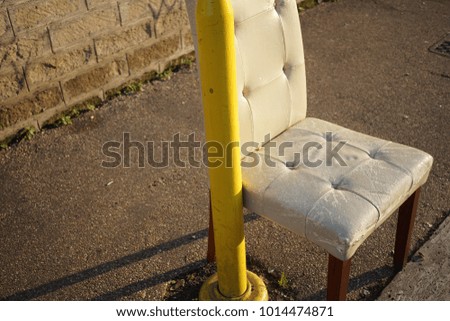 chair left near bus stop in the morning sun