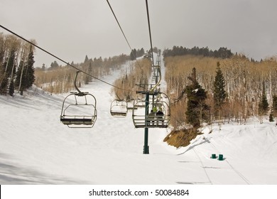 A Chair Lift Carries Skiers Through An Aspen Forest At A Resort.